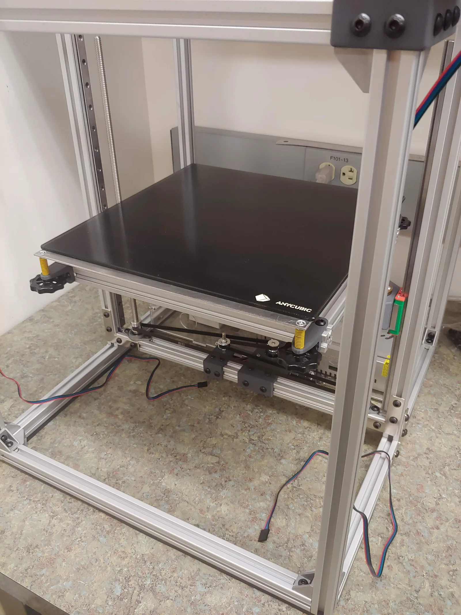 The glass build platform rests on an aluminum plate with a 750W silicone heater pad on the bottom. This plate mounts to the sub-frame with stiff yellow springs in each corner, so the bed can be coarsely leveled