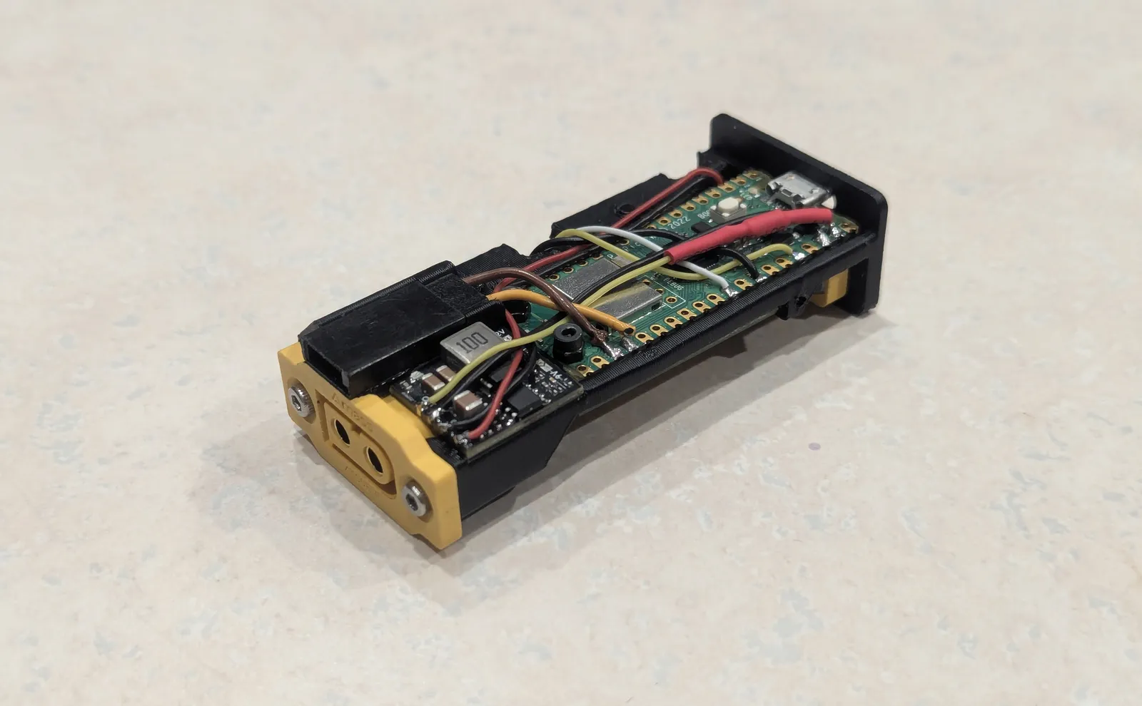 Front side of Prototype 1 without the outer case, showing the Raspberry Pi Pico W, buck converter, and servo connector on a 3D-printed sled
